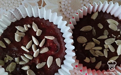 Добавить в воду растительное масло и смешать со всеми ингредиентами: овсянкой, семечками, сахаром, какао, изюмом, солью и разрыхлителем. Выложить тесто в формочки, посыпать семенами и выпекать в духовке 25 минут. 