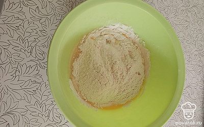 В получившуюся основу теста просеять муку, смешанную с содой.