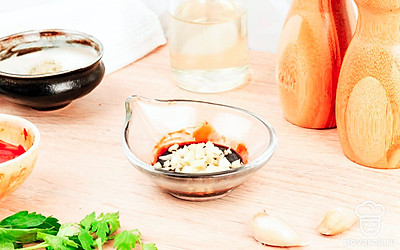 Чеснок выложите в миску и смешайте с уксусом.