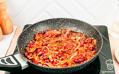 Добавьте томаты, фасоль, чеснок и винный уксус. Присыпьте хмели-сунели и готовьте еще 10 минут.