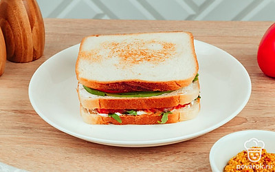 Накройте бутерброд еще одним кусочком хлеба. Нарежьте сендвич на треугольники и подавайте к столу.