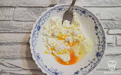 В глубокой миске соединить творог с яйцом.