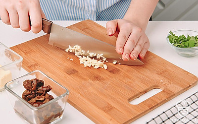 Чеснок раздавите плоской стороной ножа и измельчите.