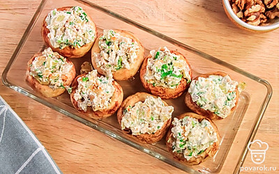 Смажьте форму для запекания растительным маслом, выложите шляпки шампиньонов и заполните начинкой.