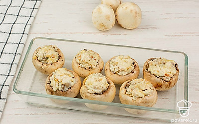 В емкость для запекания выложите шампиньоны. На каждый гриб уложите сверху начинку, можно с небольшой горкой. Отправьте в духовку, разогретую до 190 ℃, и запекайте в течение 15-20 минут.