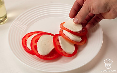 На тарелку чуть внахлест выкладывайте помидоры и моцареллу, чередуя их между собой.