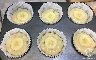 Заполнить формы для кексов получившимся тестом на 2/3. Сверху положить кружочки банана. Выпекать до золотистого цвета при температуре 200 градусов около 25 минут. Готовность проверить шпажкой (она должна выходить сухой).