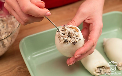 Наполните кальмары сырно-грибной массой. Зафиксируйте деревянными шпажками, выложите в форму для запекания и отправьте на 8 минут в духовку, разогретую до 200°C.