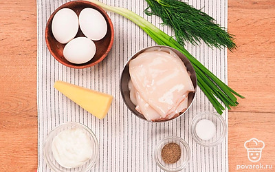 Тушки кальмаров нужно тщательно очистите и промойте под водой. Опустите их в кипящую подсоленную воду на 2-3 минуты, а затем остудите. Переваренные кальмары могут испортить блюдо и сделать его слишком жестким. Сварите яйца вкрутую, остудите и очистите от скорлупы. Вымойте и обсушите свежую зелень. Нарежьте яйца небольшими кубиками. Зелень измельчите. Сыр натрите на терке. Приготовьте форму для запекания и пергамент. Включите духовку на 150 градусов.