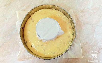 Смешайте тесто с семечками, орехами и изюмом. Форму для выпечки устелите пергаментом, а в центр установите какую-то емкость, например, металлическую чашку. Оберните ее пергаментом и установите в центр, вокруг вылейте тесто и поставьте выпекаться в духовой шкаф на 35-45 минут при температуре 170°С.