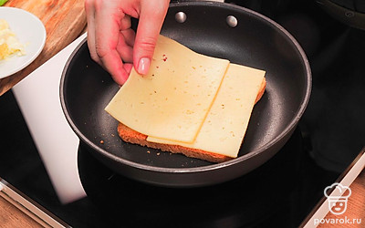 Выложите 2 кусочка хлеба на холодную сухую сковороду «маслом вниз», сверху смажьте их тонким слоем горчицы и выложите на горчицу кусочки сыра. Накройте сыр оставшимися двумя кусочками хлеба «маслом вверх».