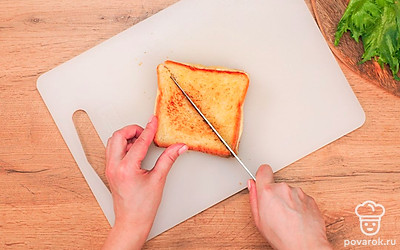 Выложите закрытые бутерброды на разделочную доску и разрежьте по диагонали каждый сэндвич. Классический рецепт предполагает именно такую треугольную форму готового блюда.