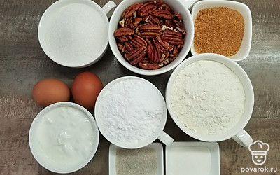 Просейте муку и смешайте ее с разрыхлителем, ванильным сахаром и солью. Отмерьте необходимое количество продуктов. Размягчите масло, и измельчите орехи в кухонном комбайне. Приготовьте небольшие формочки для кексов и включите духовку на разогрев на 160 ºС.