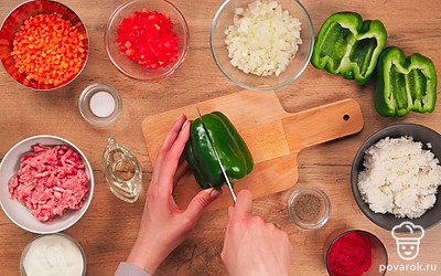 Промойте мясо и пропустите через мясорубку. Рис проварите в течение 20 минут. Вымойте овощи, очистите лук и морковь, извлеките семена из перца. Измельчите луковицу и морковь. Нарежьте помидор на небольшие кусочки. Если перец крупный, разрежьте его пополам.
