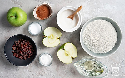 Муку просейте. Изюм залейте кипятком, затем промойте под холодной водой и обсушите. Яблоки вымойте, удалите сердцевину и разрежьте на 4 части каждое. Форму для выпечки застелите пергаментной бумагой. Разогрейте духовку до 180 градусов.