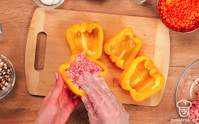 Приготовьте начинку и нафаршируйте перцы. В миску поместите мясной фарш и лук. Посолите, поперчите и тщательно перемешайте. Наполните перцы фаршем.