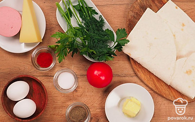 Расположите удобно все продукты. Промойте, просушите и накрошите зелень. Натрите заранее сыр на крупной терке. Колбасу нарежьте маленькими кубиками. Помидор нарежьте кружочками. Растопите сливочное масло в микроволновой печи. Подготовьте толстостенную сковороду, венчик, кулинарную кисточку.