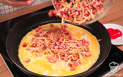 Выложите на сковороду первый лаваш и вылейте на него взбитые яйца. Через полминуты, когда яичная смесь немного схватится, выложите на яичный слой подготовленную начинку и равномерно распределите ее. Накройте вторым лавашем и смажьте его сверху растопленным маслом при помощи кисточки.