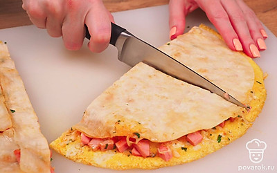 Разрежьте готовый большой сэндвич из лаваша на порционные куски и подавайте.