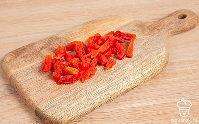 Помойте курагу и порежьте на небольшие кусочки. Орехи измельчите.