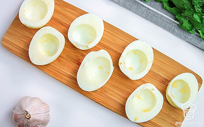 Разрежьте яйца пополам и отделите желтки от белков. Желтки измельчите.