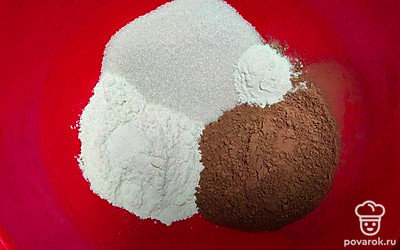 В глубокую емкость высыпьте сухие ингредиенты: сахар, просеянную пшеничную муку, какао-порошок и разрыхлитель. Хорошо перемешайте.