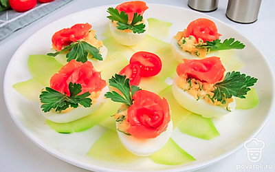 Тарелку можете украсить ломтиками огурца и цуккини. На фаршированные яйца можно положить красную икру, чтобы сделать блюдо более аппетитным.