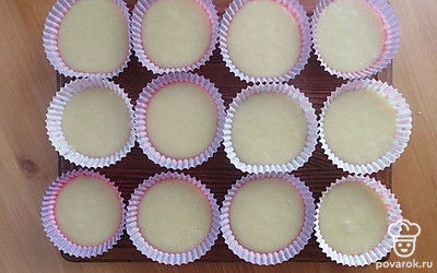 Добавьте в тесто сок лимонов и перемешайте. В последнюю очередь добавьте лимонную цедру. Ещё раз тщательно перемешайте. Выложите тесто в бумажные или силиконовые формочки для кексов, заполняя их примерно на две трети. Поместите формочки с тестом в предварительно разогретую до 180°C духовку. Выпекайте кексы примерно 25–30 минут.