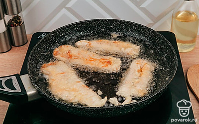 Нарежьте курицу полосками, затем обмакните ее в кляр и отправьте в кипящее масло на 3-4 минуты.