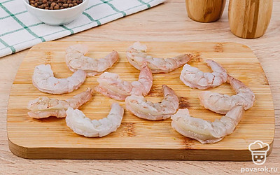 Креветки промойте, очистите и выложите на деревянную доску.