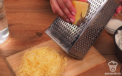 Сыр натрите на терке. Отделите желток от белка. Удобно разложите на столе ингредиенты. Приготовьте противень и пергаментную бумагу. Поставьте духовой шкаф на разогрев до 180 ˚C.