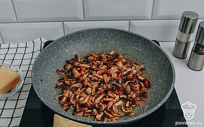 На разогретой с растительным маслом сковороде обжарьте шампиньоны до полуготовности в течение 5-7 минут.