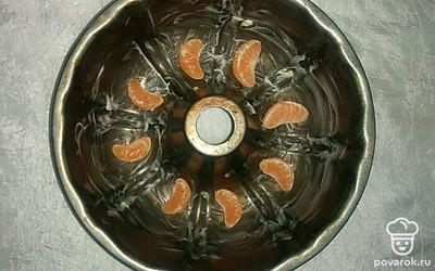 На дно смазанной сливочным маслом формы для кекса выложите дольки мандарина. Залейте форму тестом и поставьте все в разогретую до 180℃ духовку на 50 минут. Готовый кекс достаньте из духовки и оставьте на 15 минут, чтобы он немного остыл, затем извлеките из формы и поместите на решетку до полного остывания.