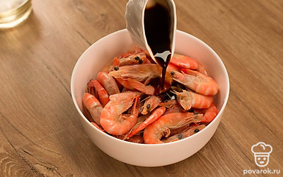 Поместите очищенные креветки в миску, добавьте соевый соус, чеснок, перемешайте и оставьте мариноваться на 20 минут.