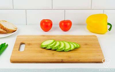 Цукини нарежьте кружочками, выложите на противень, застеленный пергаментом, и запеките в духовке 5 минут при 180 °С.