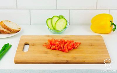 У перца удалите плодоножку и семяна. Зеленый лук нарежьте мелким кубиком. Помидоры бланшируйте. Для этого сделайте на них крестовые надрезы, опустите в кипящую воду в кастрюле, подержите в кипятке в течение 1 минуты. Затем резко опустите в ледяную воду и снимите кожицу. Затем нарежьте помидоры кубиком.