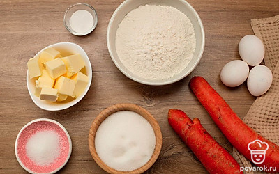 Очистите морковь и натрите на мелкой терке, просейте муку вместе с разрыхлителем и растопите сливочное масло. Разогрейте духовку до 180°C.