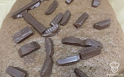 Выложите шоколадные полоски на горячий бисквит.