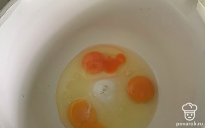 Натрите морковь на мелкой терке и нарубите мелко орехи. Отложите. Разбейте в миску яйца.