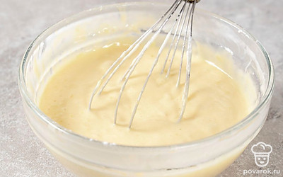 Всыпьте к взбитым с сахаром яйцам муку и разрыхлитель для теста. Замесите жидкое бисквитное тесто с помощью ложки или лопатки.
