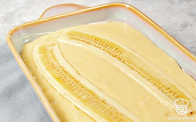 Поверх теста уложите половинки банана срезами вверх.