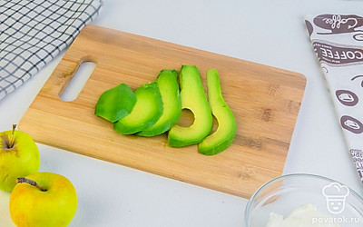 Авокадо очистите от кожуры и косточки с помощью ножа или ложки. У яблока удалите кожицу, плодоножку и семена. Нарежьте авокадо и яблоко на ломтики.