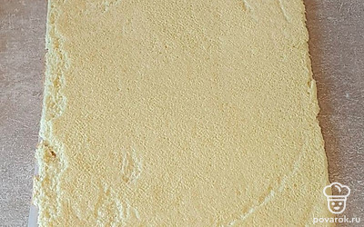 Готовый бисквит сразу переверните верхушкой вниз, выложив на полотенце или пергамент. Бумагу, на которой выпекался корж, аккуратно снимите, дайте полностью остыть. Бисквит не нужно скручивать в рулет заранее, он и после остывания остается эластичным и хорошо скручивается.