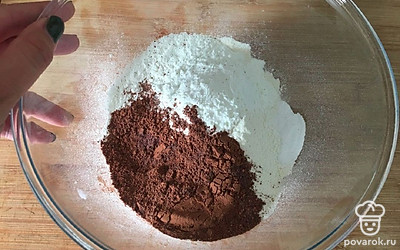 В миске смешайте сухие ингредиенты. Просейте муку, добавьте соду, крахмал, какао-порошок и соль. Перемешайте лопаткой.