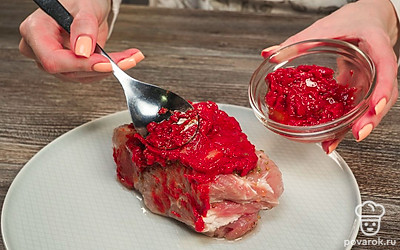 Подготовьте свинину к запеканию. Соедините томатную пасту с маслом и перемешайте. Достаньте мясо из рассола, смажьте со всех сторон. Заверните в фольгу, плотно закрыв края.