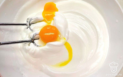 Взбейте белки до стойких пиков. Затем частями подсыпьте сахар и взбейте. После этого по одному введите желтки и также взбейте.