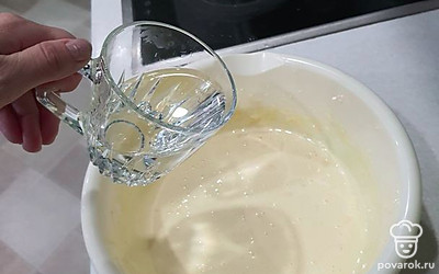 Добавить в массу с желтками 150 миллилитров тёплой воды. Перемешать. 