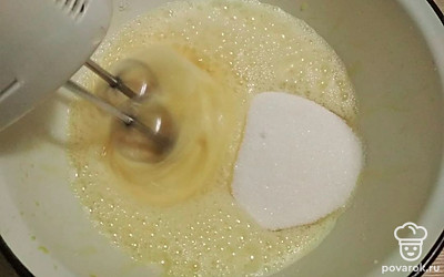 Яйца с сахаром взбейте миксером до плотной густой пены. Добавьте 1/3 часть муки и осторожно перемешайте лопаткой. Влейте 1/3 часть горячего молока с маслом, аккуратно перемешайте. Дважды повторите поочередное введение муки и молока. Вылейте тесто в форму диаметром 24-26 см, дно которой застелено бумагой для выпечки. Можно выпекать сразу в двух формах меньшего размера, в этом случае время выпекания сократите.