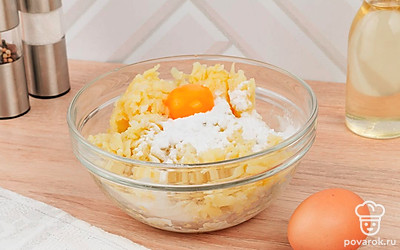 Смешайте в глубокой миске натертый картофель, крахмал, одно яйцо, молоко и специи.