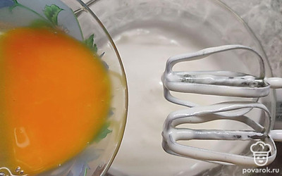 Отдельно взболтайте венчиком или вилкой желтки и также постепенно добавьте их к взбитым белкам. Взбивайте миксером еще около 2-3 минут.